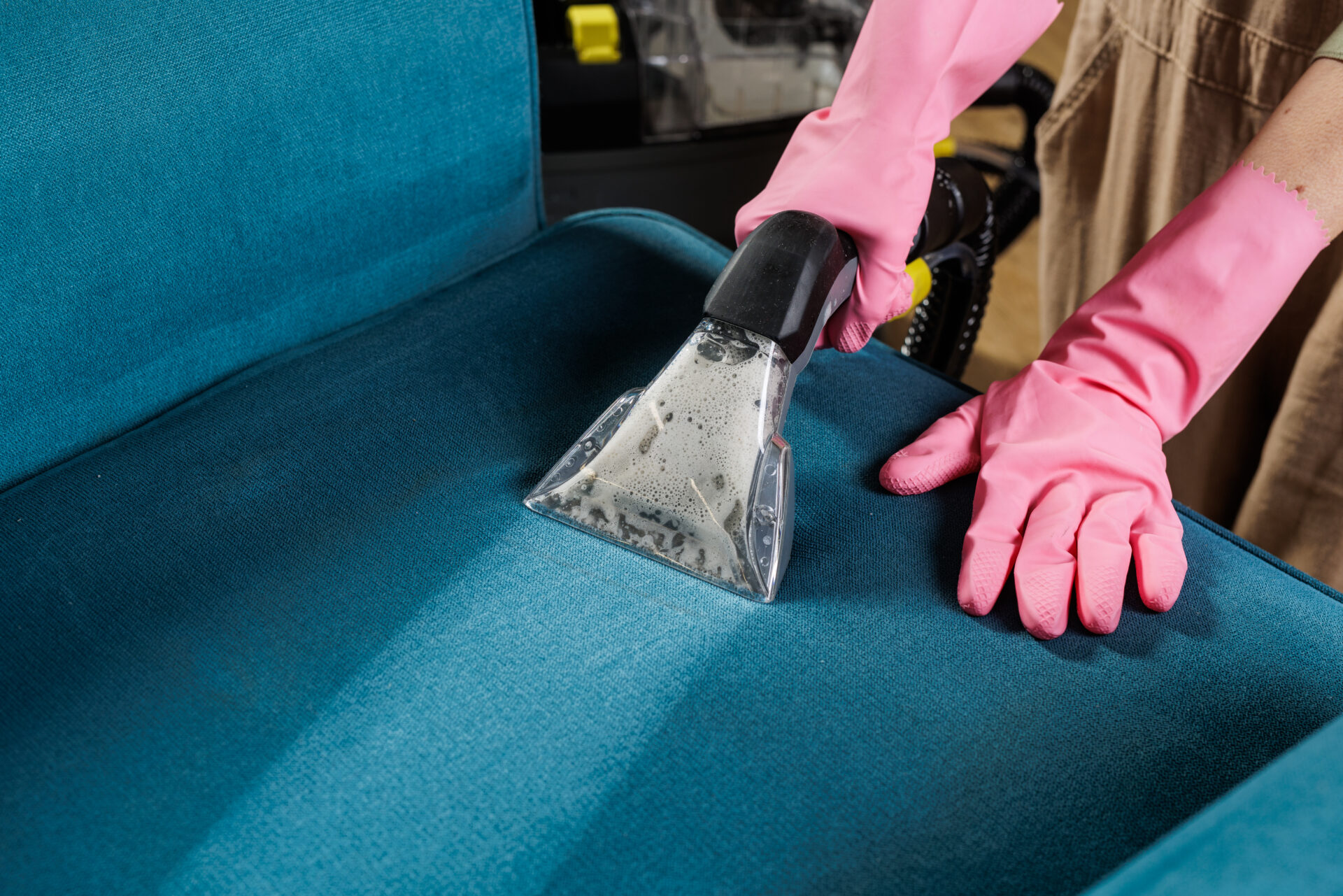 Worker in pink gloves using extractor